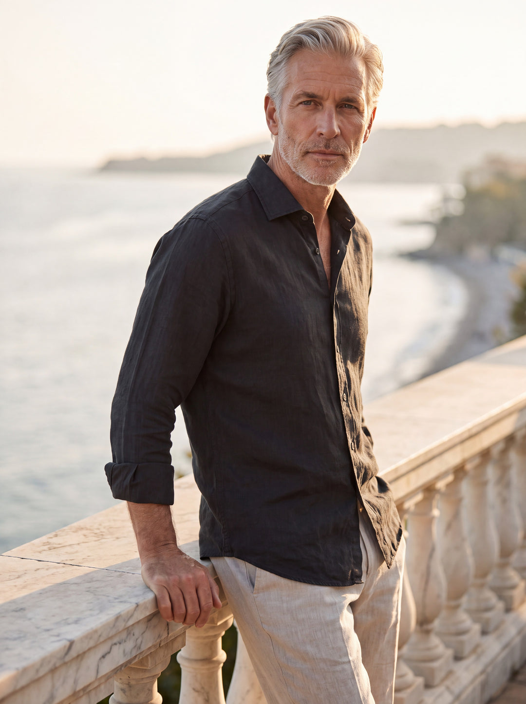 Albert Men linen shirt in black, worn by a model on a Mediterranean terrace - Gentlemens Manor lifestyle