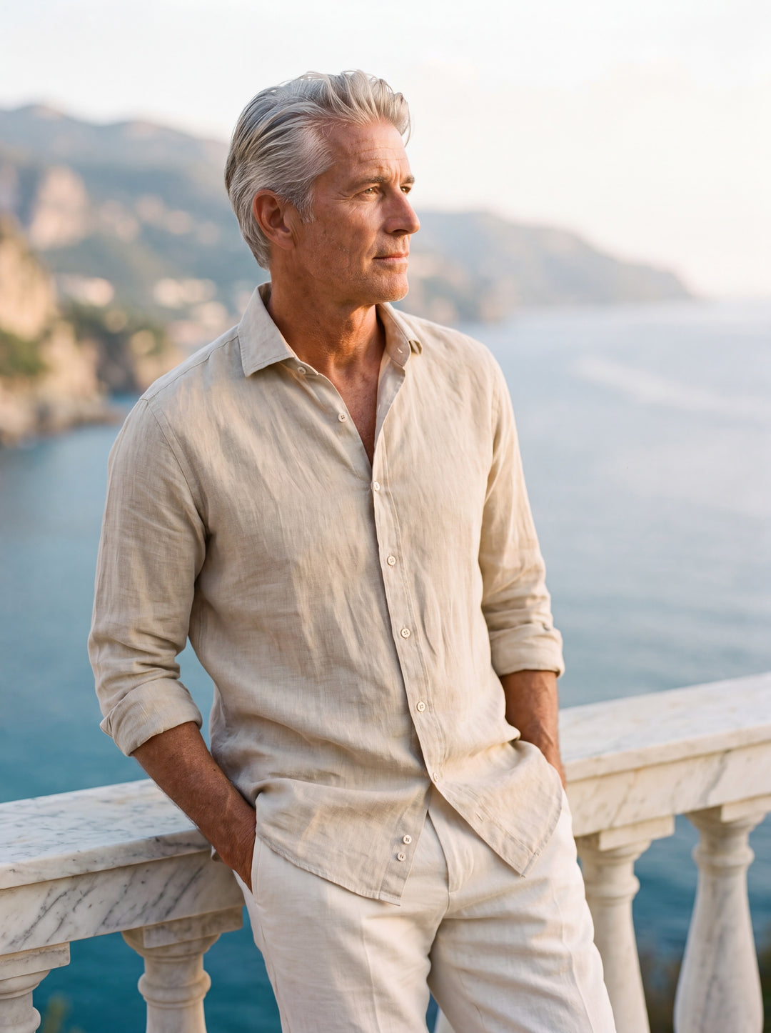 Albert Men linen shirt in Sand, worn by a model on a Mediterranean terrace - Gentlemens Manor lifestyle