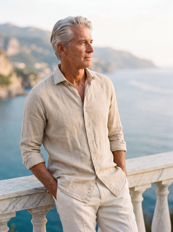 Albert Men linen shirt in Sand, worn by a model on a Mediterranean terrace - Gentlemens Manor lifestyle