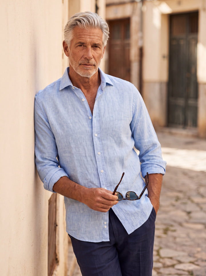 Albert Men linen shirt in Light Blue, worn by a model on a Mediterranean terrace - Gentlemens Manor lifestyle