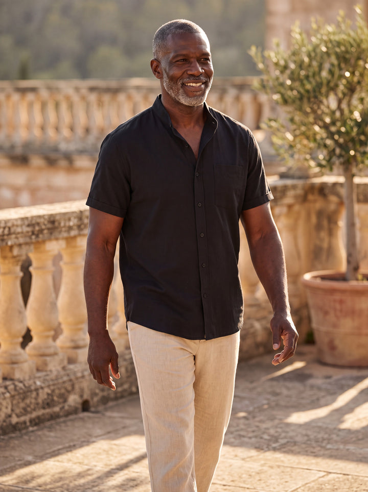 Ambrose Men short sleeve shirt in black, worn by a model on a Mediterranean terrace - Gentlemens Manor lifestyle