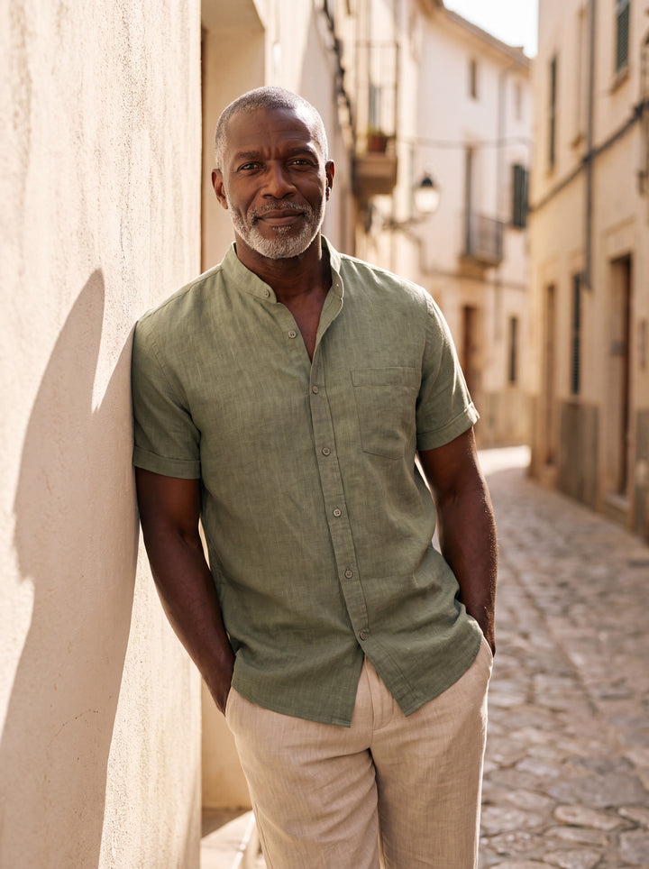 Ambrose Men short sleeve shirt in green, worn by a model on a Mediterranean terrace - Gentlemens Manor lifestyle