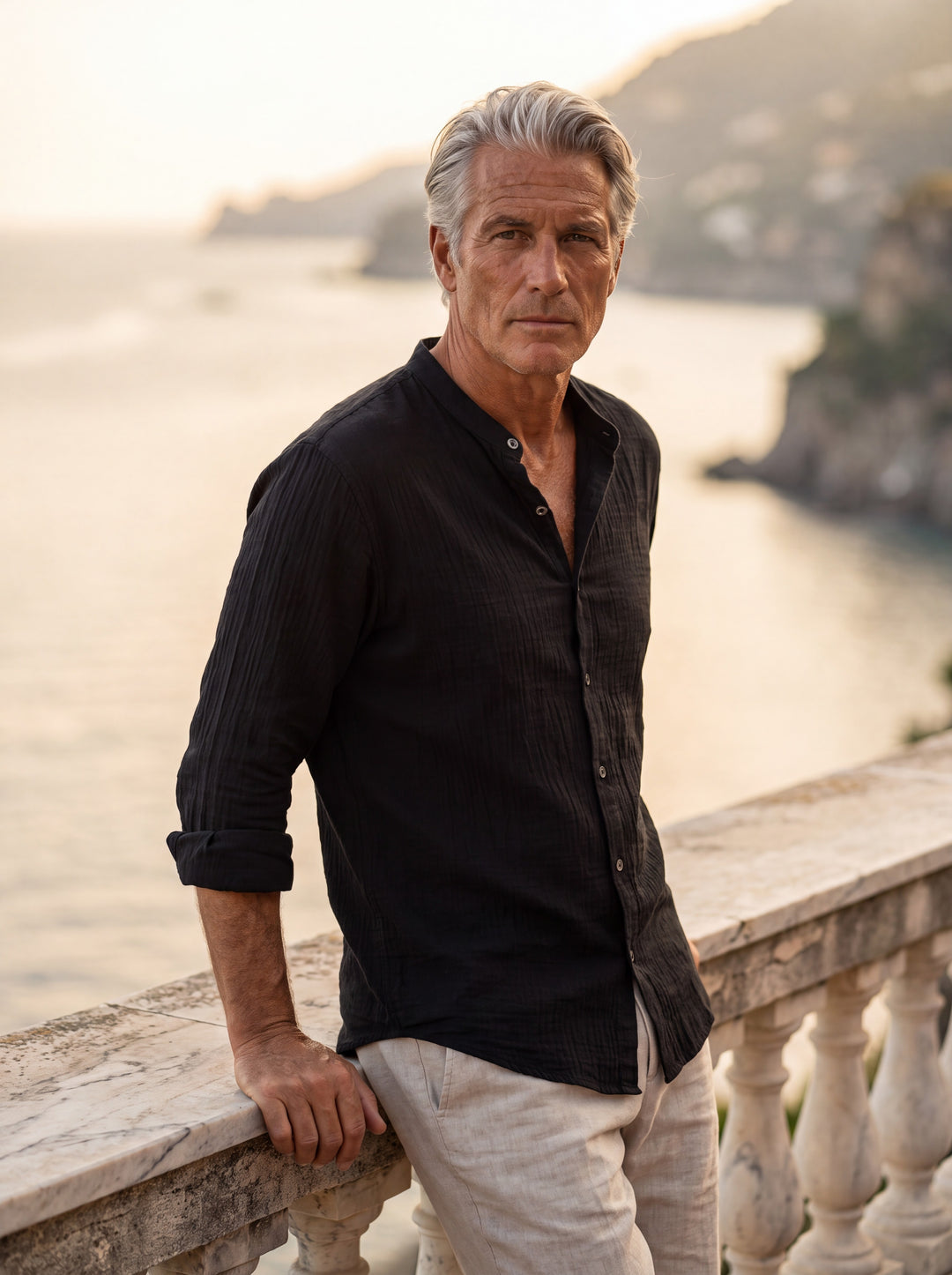 Amos Men linen shirt in black, worn by a model on a Mediterranean terrace - Gentlemens Manor lifestyle