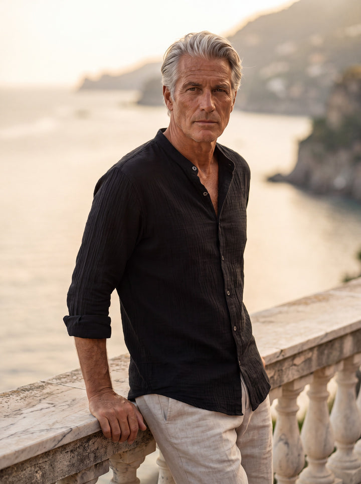 Amos Men linen shirt in black, worn by a model on a Mediterranean terrace - Gentlemens Manor lifestyle