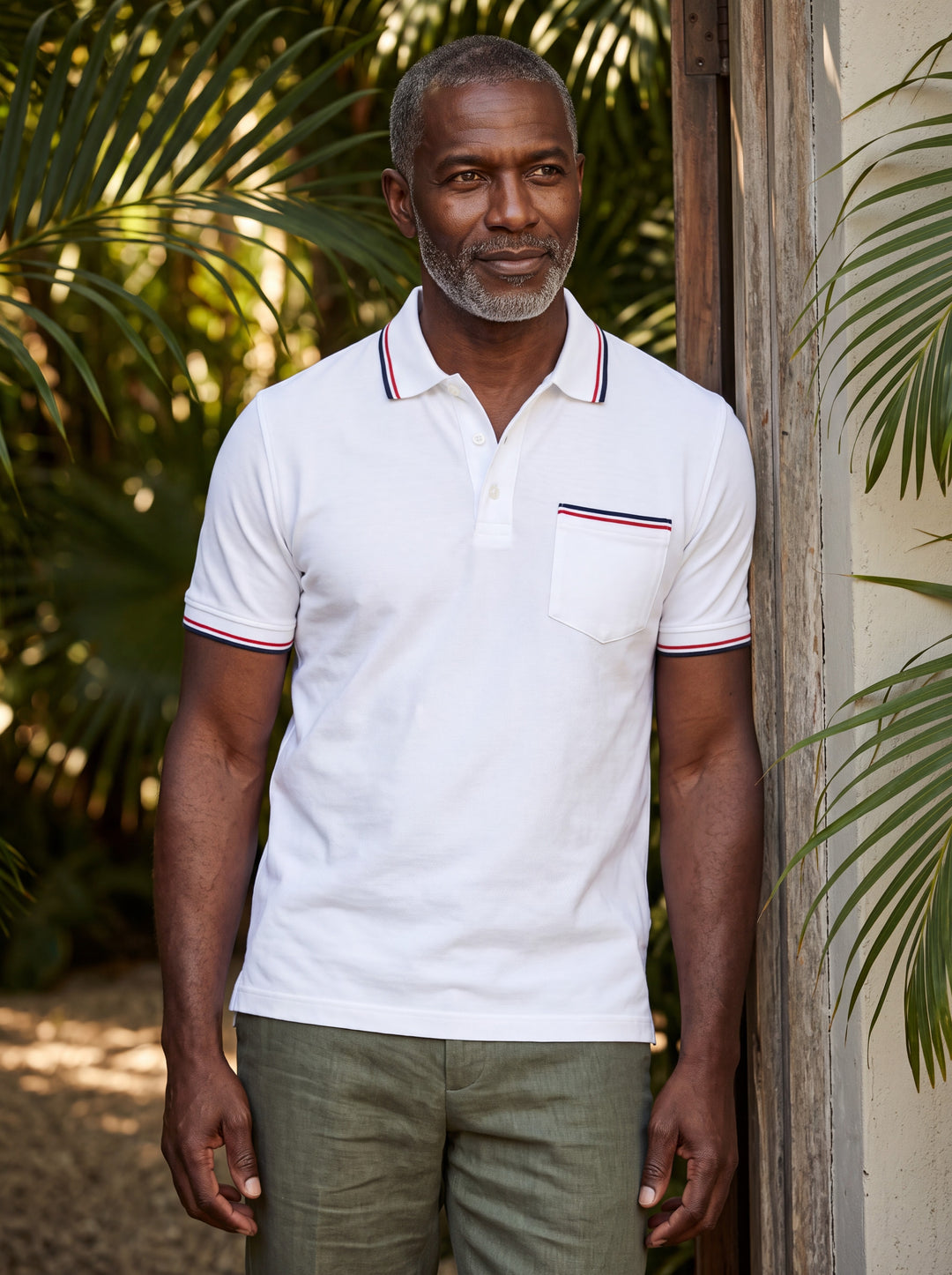 Anderson Men polo shirt in white, worn by a model on a Mediterranean terrace - Gentlemens Manor lifestyle