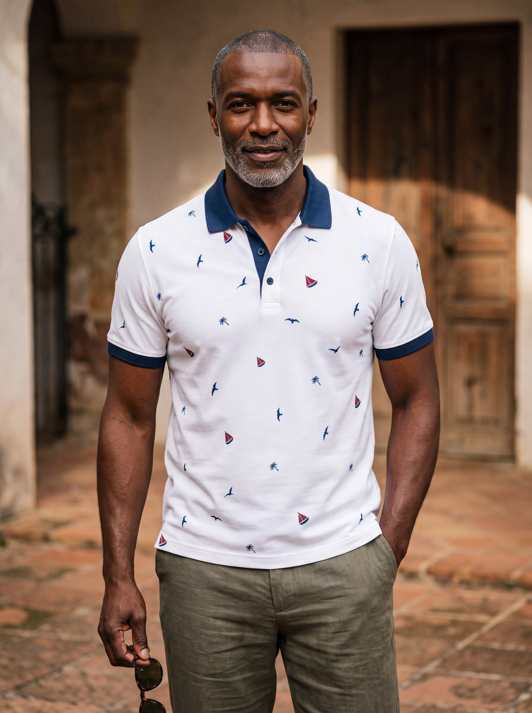 Archibald Men polo shirt in white, worn by a model on a Mediterranean terrace - Gentlemens Manor lifestyle