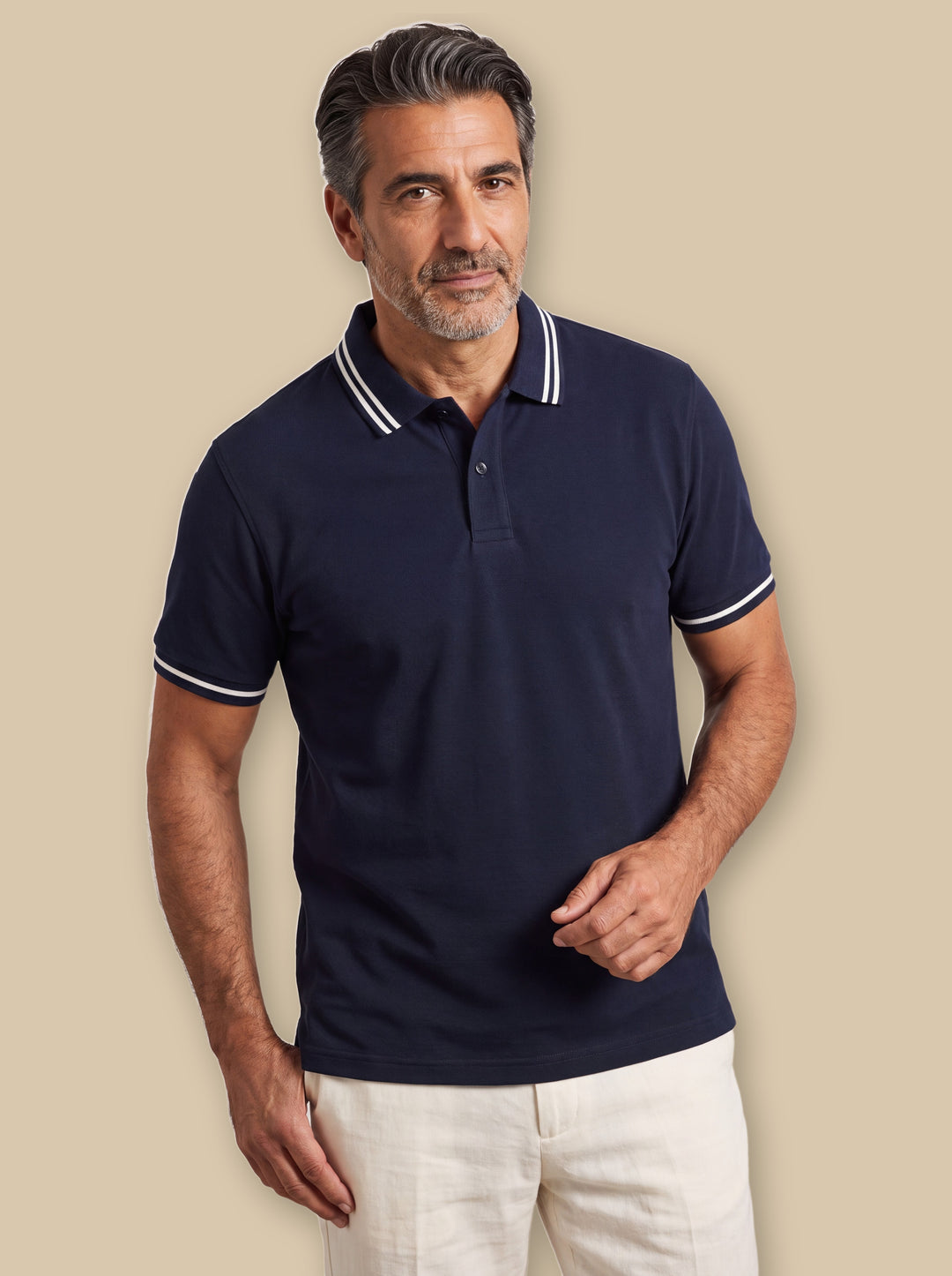 Arnold polo shirt in Navy, worn by a model on a warm sand studio background - Gentlemens Manor