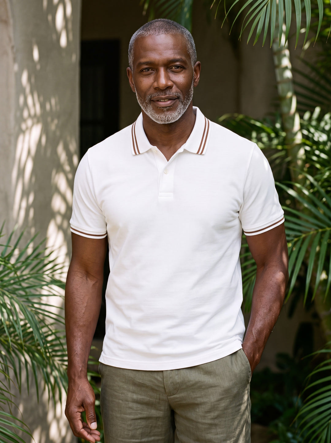 Arnold Men polo shirt in white, worn by a model on a Mediterranean terrace - Gentlemens Manor lifestyle