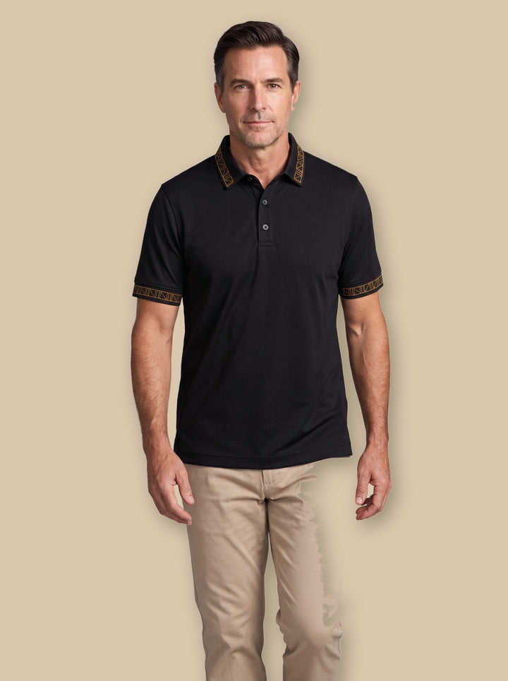 Arthur polo shirt in Black, worn by a model on a warm sand studio background - Gentlemens Manor