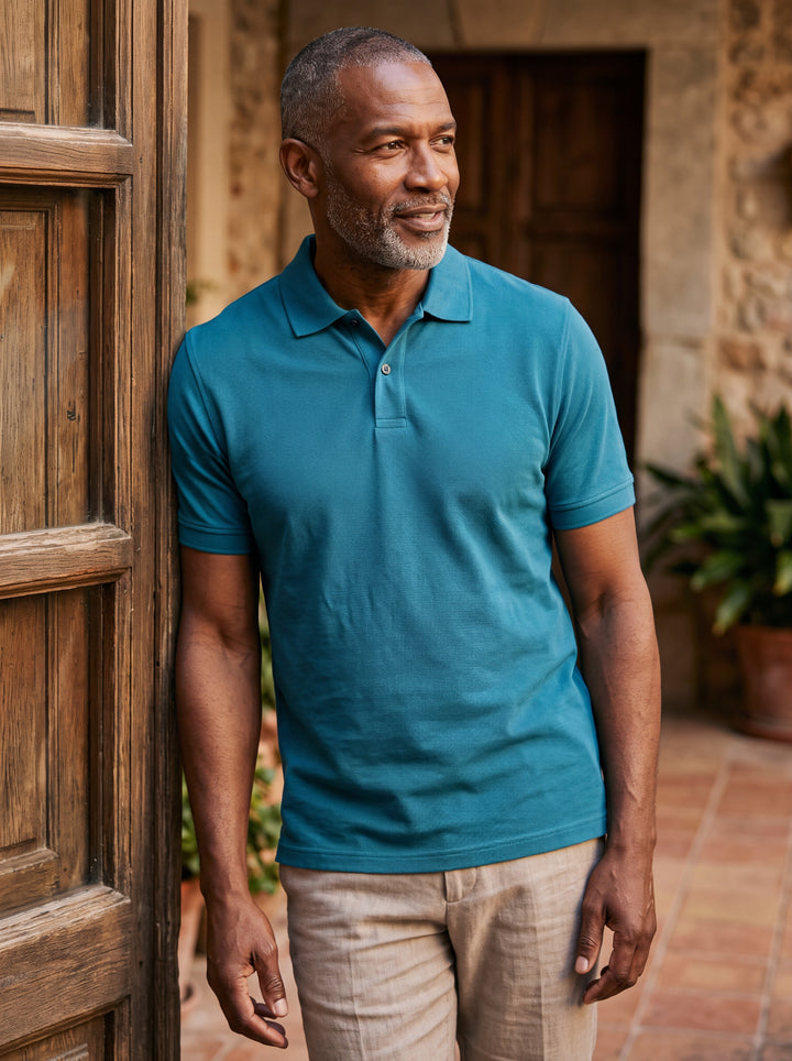 Asa Men polo shirt in blue, worn by a model on a Mediterranean terrace - Gentlemens Manor lifestyle