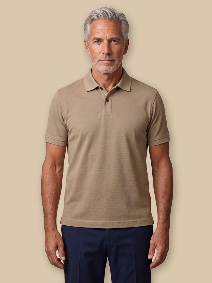 Asa polo shirt in Sand, worn by a model on a warm sand studio background - Gentlemens Manor
