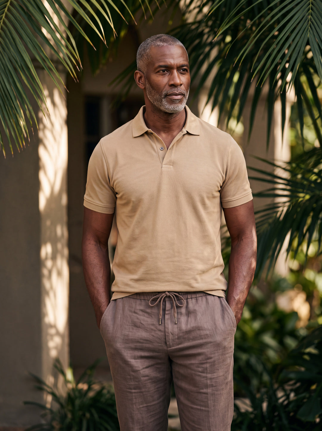 Asa Men polo shirt in sand, worn by a model on a Mediterranean terrace - Gentlemens Manor lifestyle