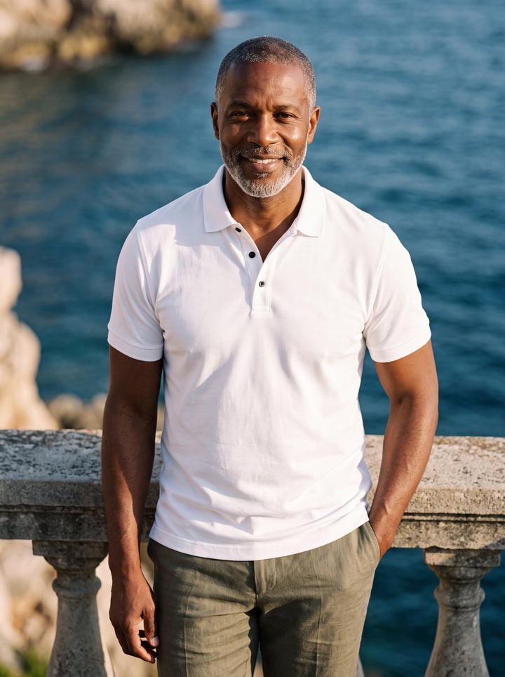 Asa Men polo shirt in white, worn by a model on a Mediterranean terrace - Gentlemens Manor lifestyle