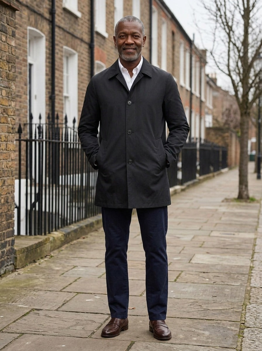 Atwell lightweight mac coat in Black, lifestyle on a street of brick row houses, Gentlemens Manor