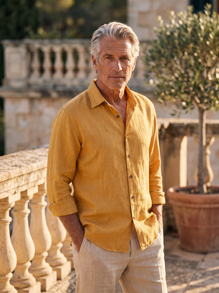 Axel Men linen shirt in Mustard, worn by a model on a Mediterranean terrace - Gentlemens Manor lifestyle