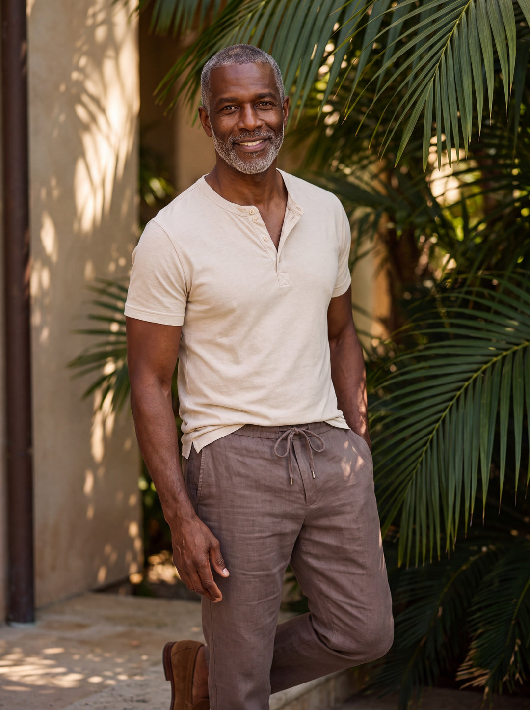 Baldwin Men henley shirt in beige, worn by a model on a Mediterranean terrace - Gentlemens Manor lifestyle