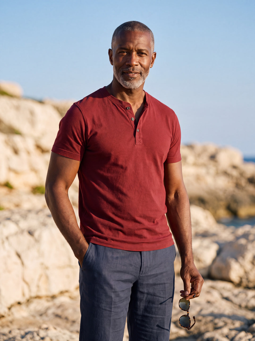 Baldwin Men henley shirt in red, worn by a model on a Mediterranean terrace - Gentlemens Manor lifestyle