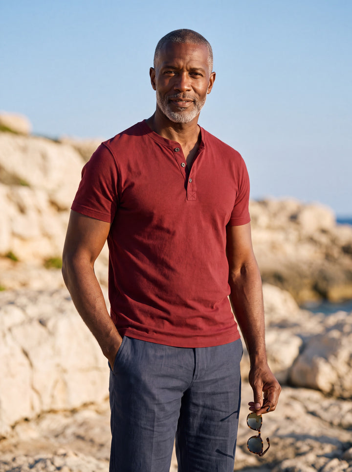 Baldwin Men henley shirt in red, worn by a model on a Mediterranean terrace - Gentlemens Manor lifestyle