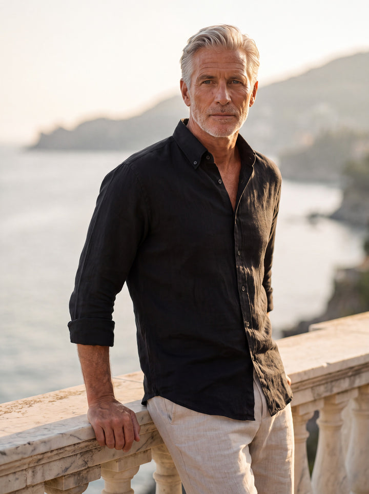 Bartholomew Men linen shirt in black, worn by a model on a Mediterranean terrace - Gentlemens Manor lifestyle