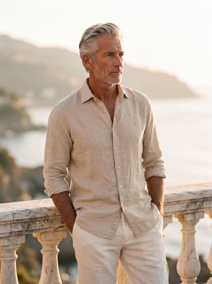 Bartholomew Men linen shirt in Sand, worn by a model on a Mediterranean terrace - Gentlemens Manor lifestyle