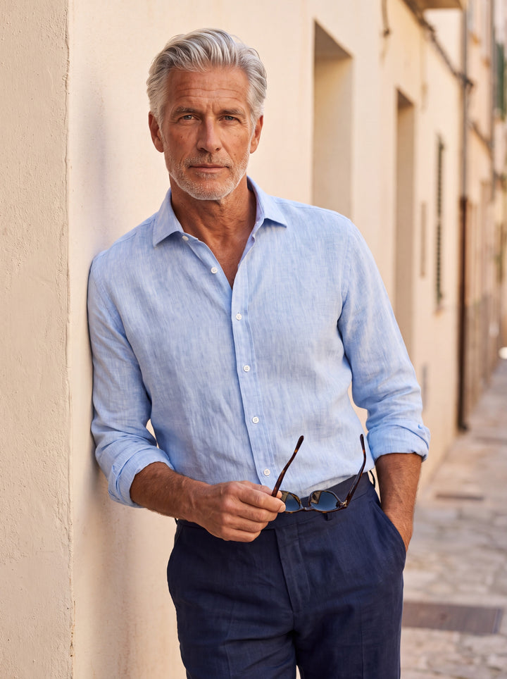 Bartholomew Men linen shirt in Light Blue, worn by a model on a Mediterranean terrace - Gentlemens Manor lifestyle