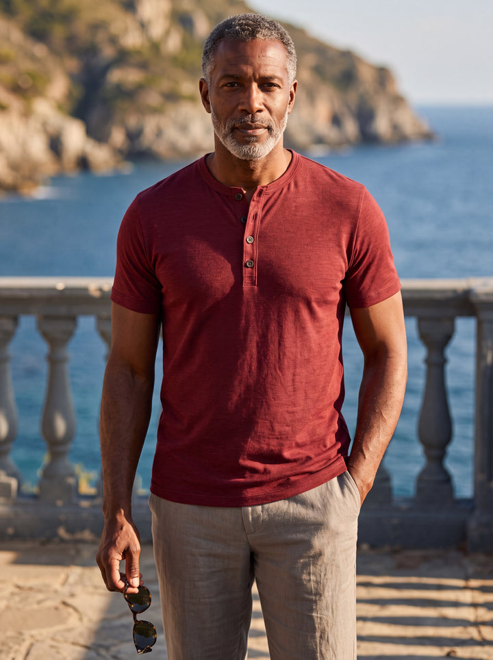 Basil Men polo shirt in burgundy, worn by a model on a Mediterranean terrace - Gentlemens Manor lifestyle