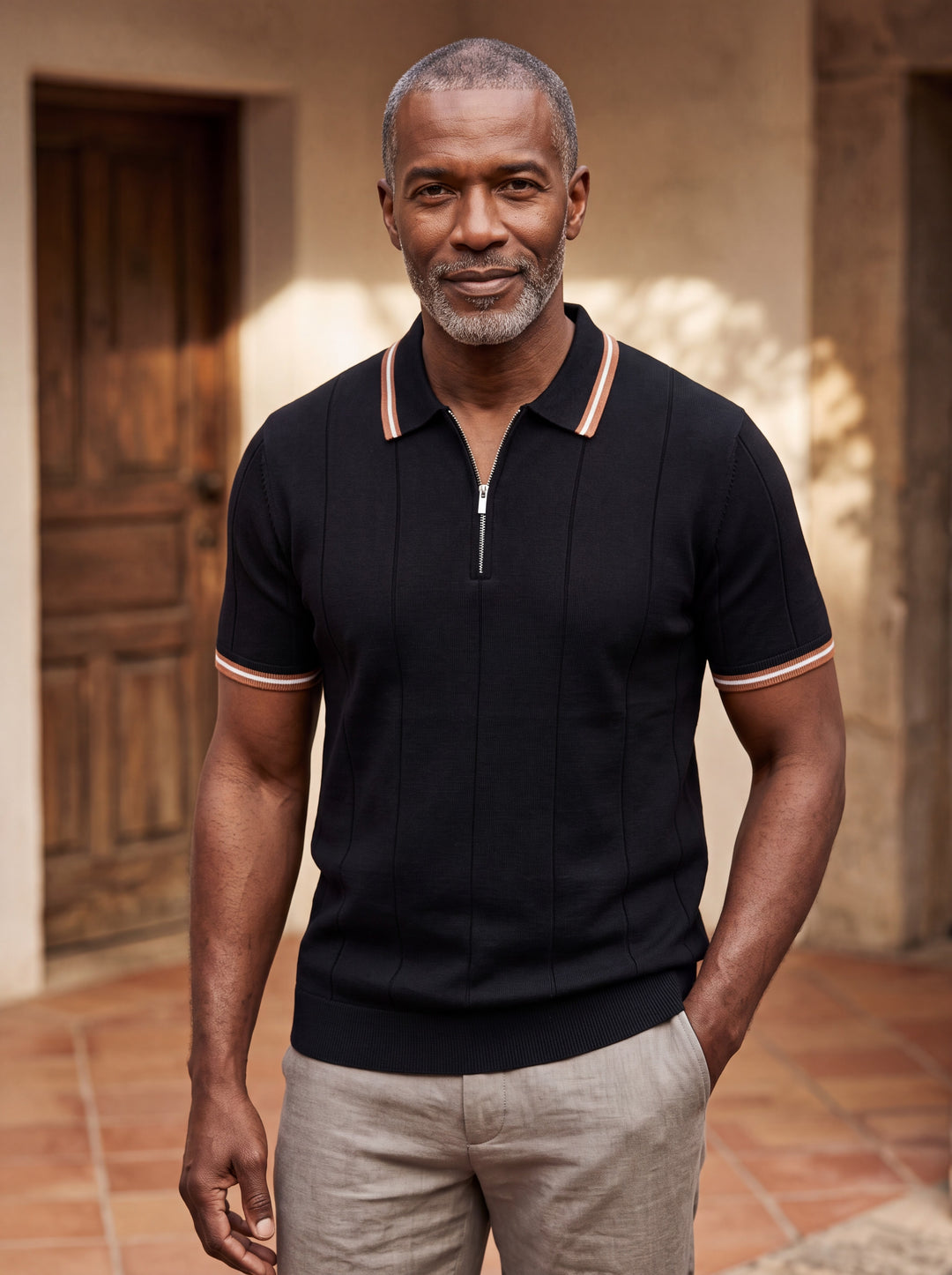 Benjamin Men polo shirt in black, worn by a model on a Mediterranean terrace - Gentlemens Manor lifestyle