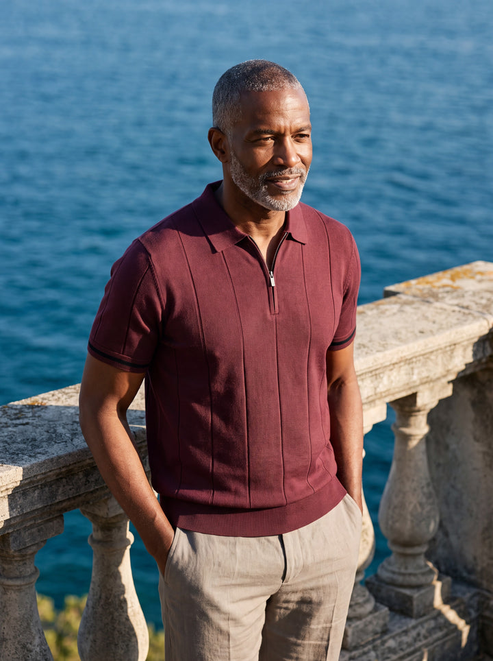 Benjamin Men polo shirt in burgundy, worn by a model on a Mediterranean terrace - Gentlemens Manor lifestyle
