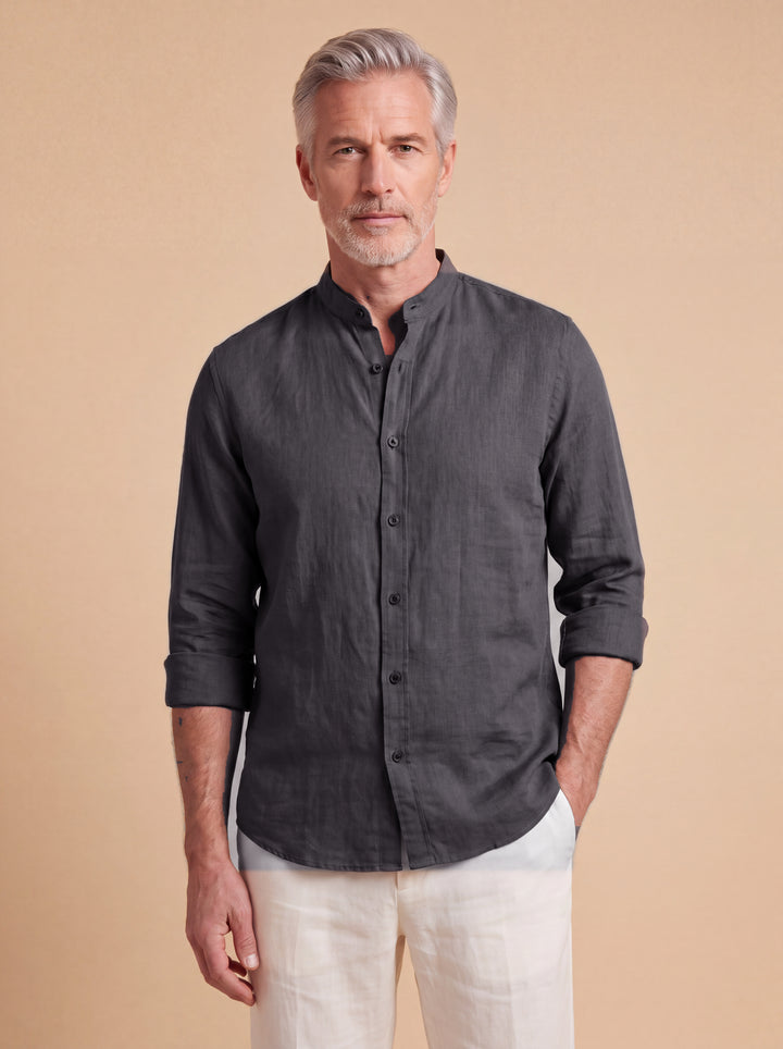 Bernard linen shirt in Charcoal with band collar, worn by a model on a warm sand studio background, Gentlemens Manor