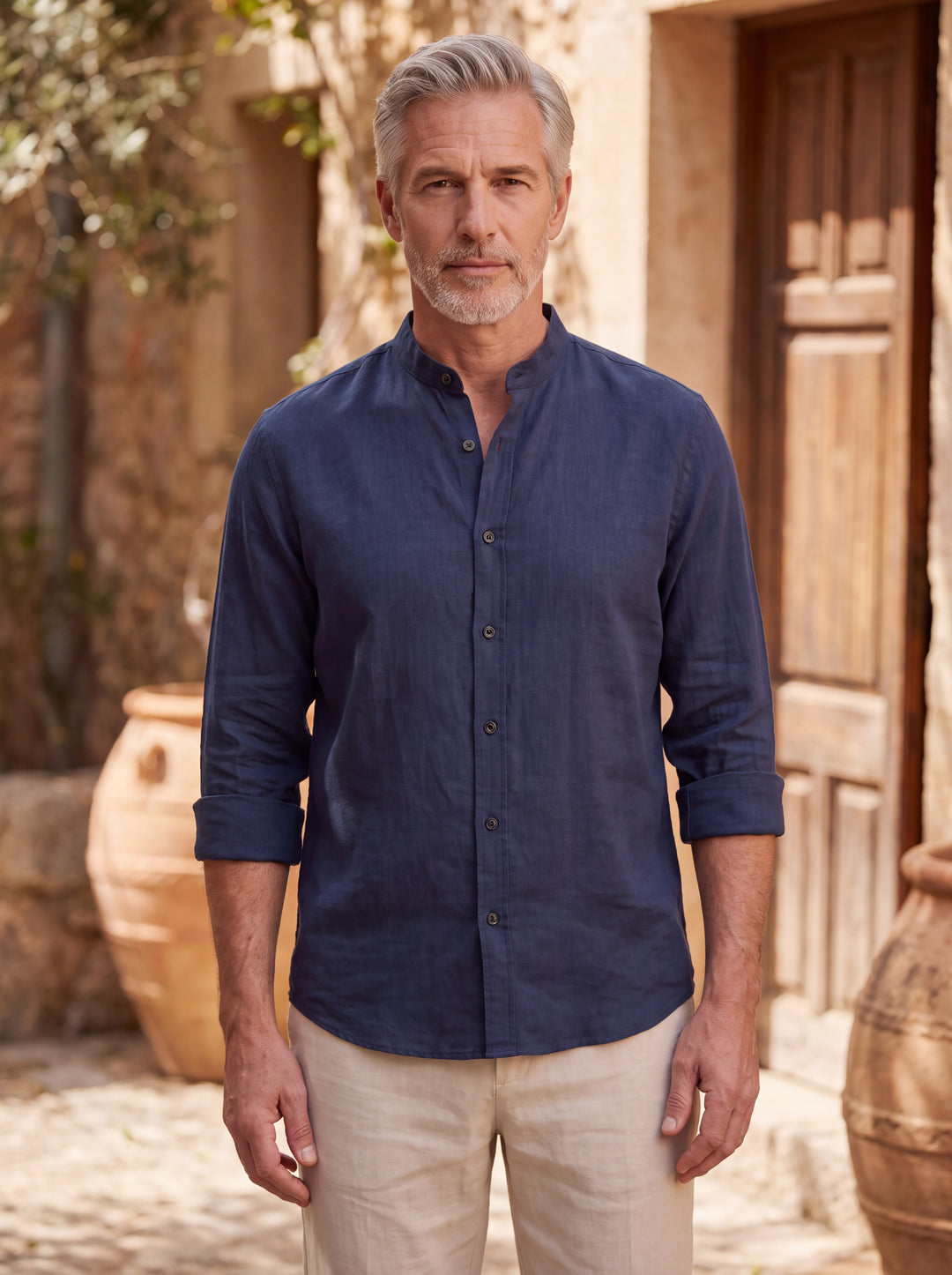 Bernard Men linen shirt in navy, worn by a model in a Mediterranean courtyard, Gentlemens Manor lifestyle