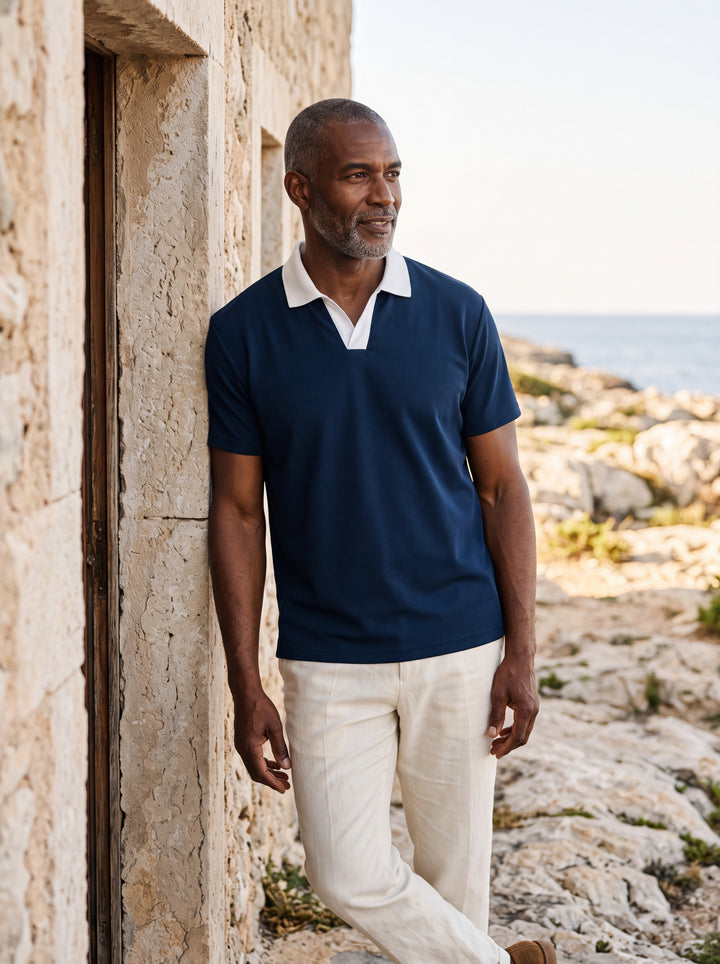 Booker Men polo shirt in navy, worn by a model on a Mediterranean terrace - Gentlemens Manor lifestyle