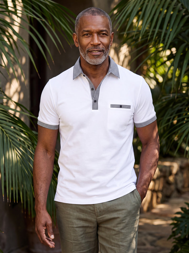 Boone Men polo shirt in white, worn by a model on a Mediterranean terrace - Gentlemens Manor lifestyle