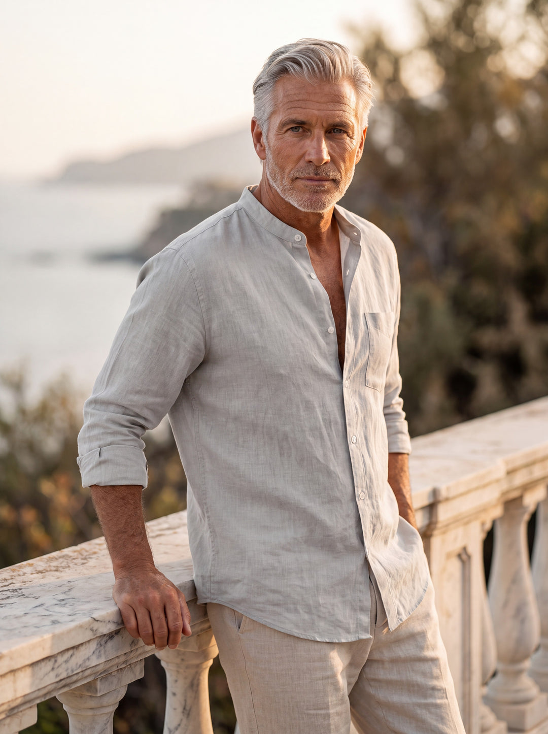 Carl Men linen shirt in light grey, worn by a model on a Mediterranean terrace - Gentlemens Manor lifestyle