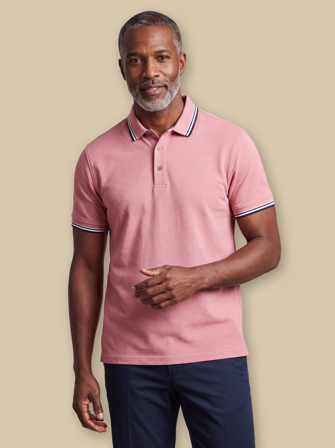 Carlton polo shirt in Burgundy, worn by a model on a warm sand studio background - Gentlemens Manor
