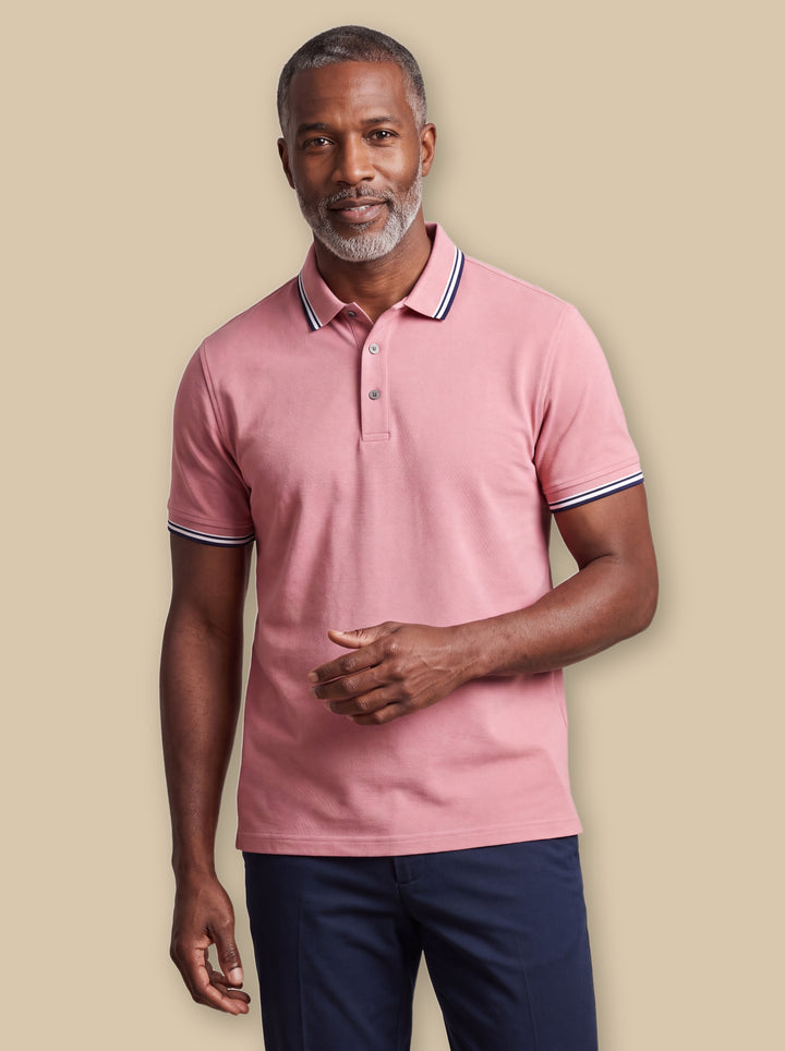 Carlton polo shirt in Burgundy, worn by a model on a warm sand studio background - Gentlemens Manor