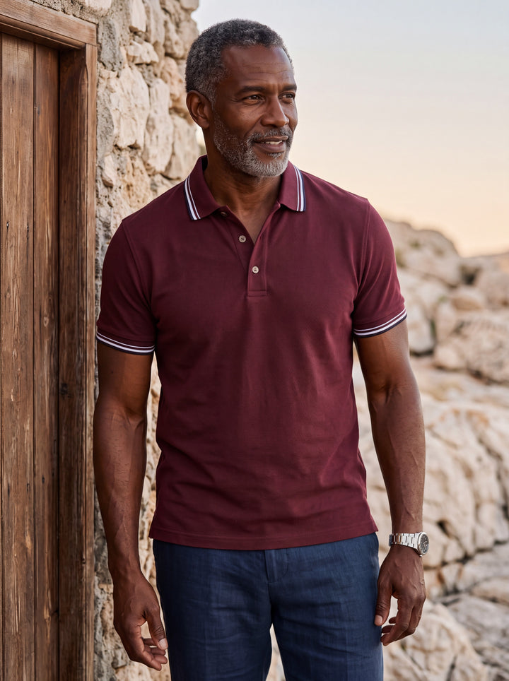 Carlton Men polo shirt in Burgundy, worn by a model on a Mediterranean terrace - Gentlemens Manor lifestyle