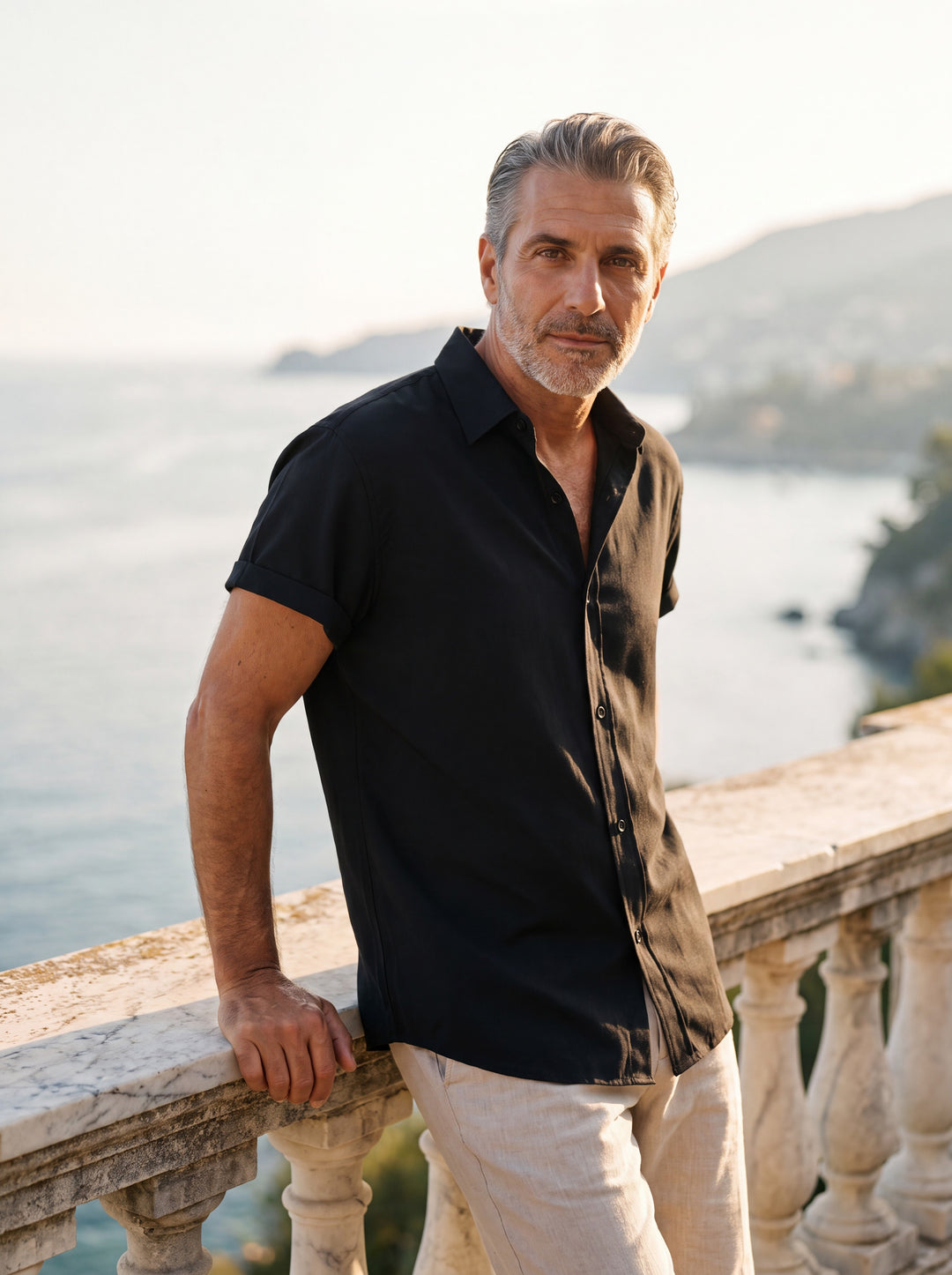 Carlton Men short sleeve shirt in black, worn by a model on a Mediterranean terrace - Gentlemens Manor lifestyle