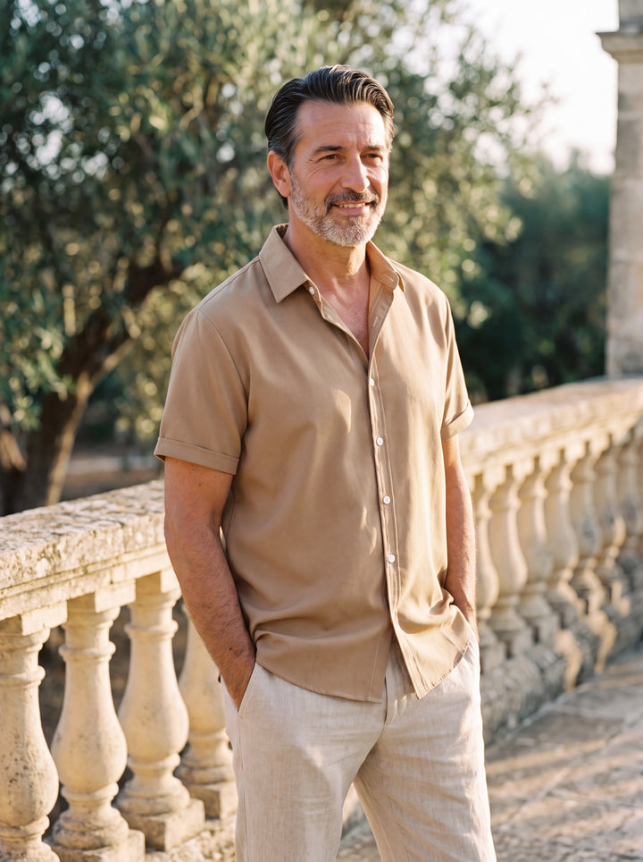 Carlton Men short sleeve shirt in Sand, worn by a model on a Mediterranean terrace - Gentlemens Manor lifestyle