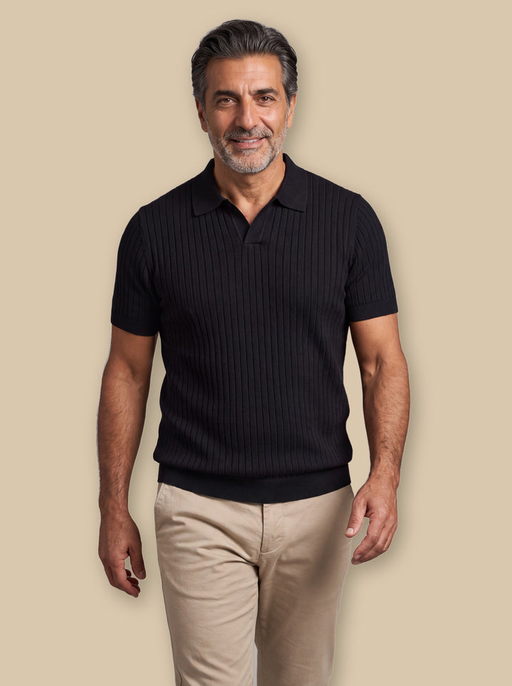 Clarence polo shirt in Black, worn by a model on a warm sand studio background - Gentlemens Manor
