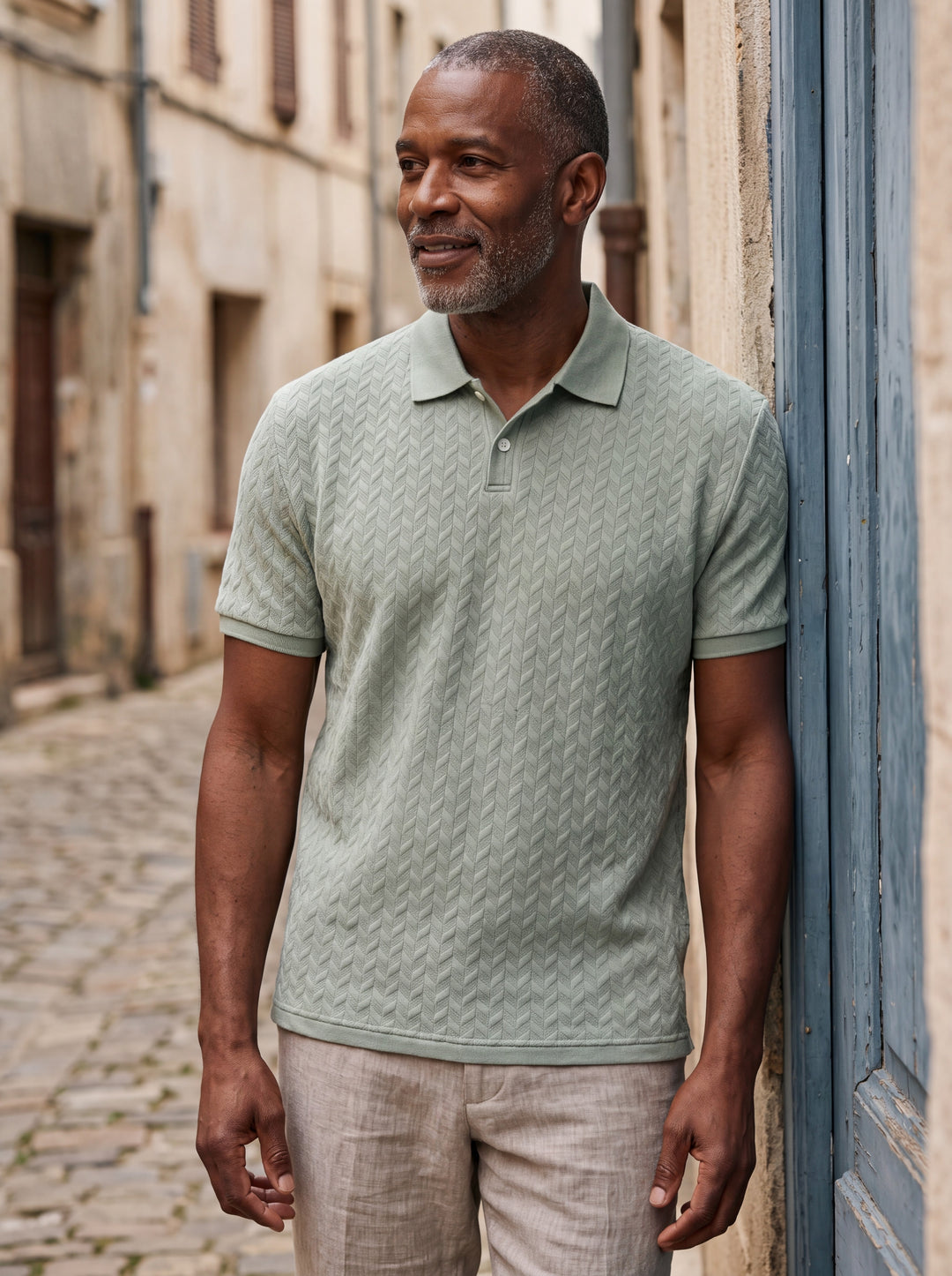 Clifford Men polo shirt in green, worn by a model on a Mediterranean terrace - Gentlemens Manor lifestyle
