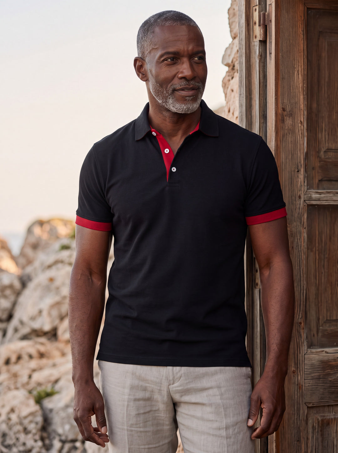 Clyde Men polo shirt in black, worn by a model on a Mediterranean terrace - Gentlemens Manor lifestyle