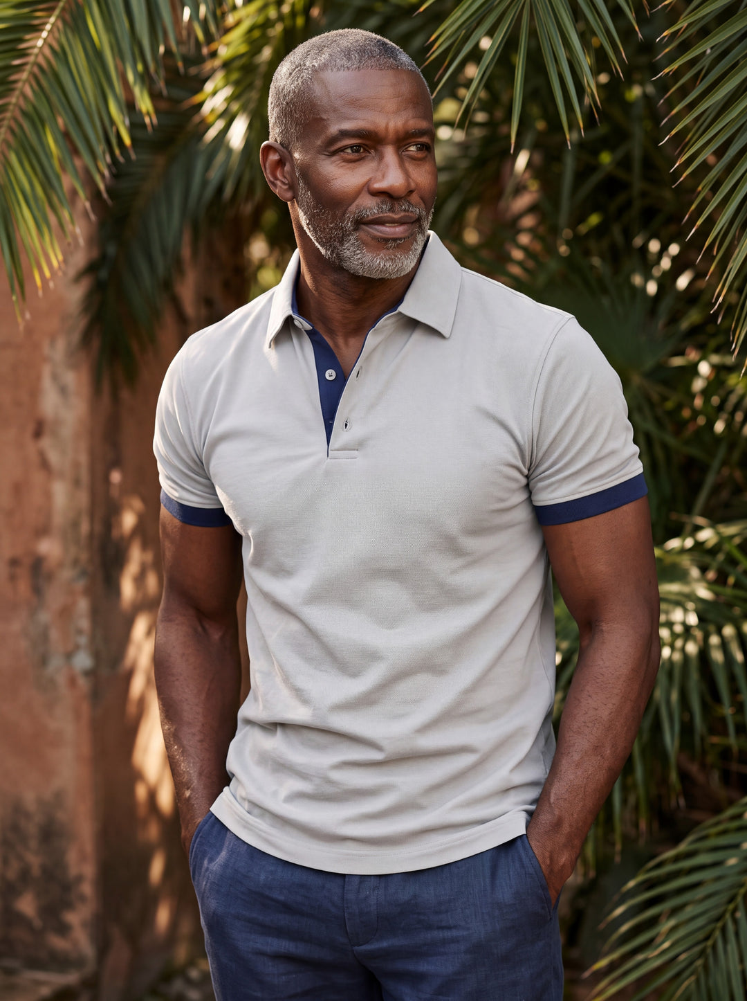 Clyde Men polo shirt in light grey, worn by a model on a Mediterranean terrace - Gentlemens Manor lifestyle