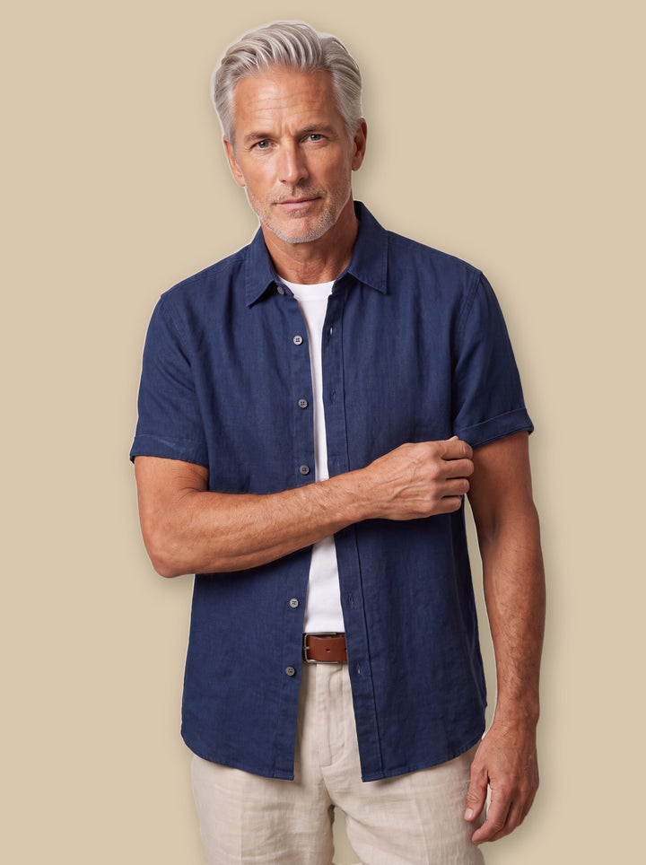 Cole linen shirt in Navy, worn by a model on a warm sand studio background - Gentlemens Manor