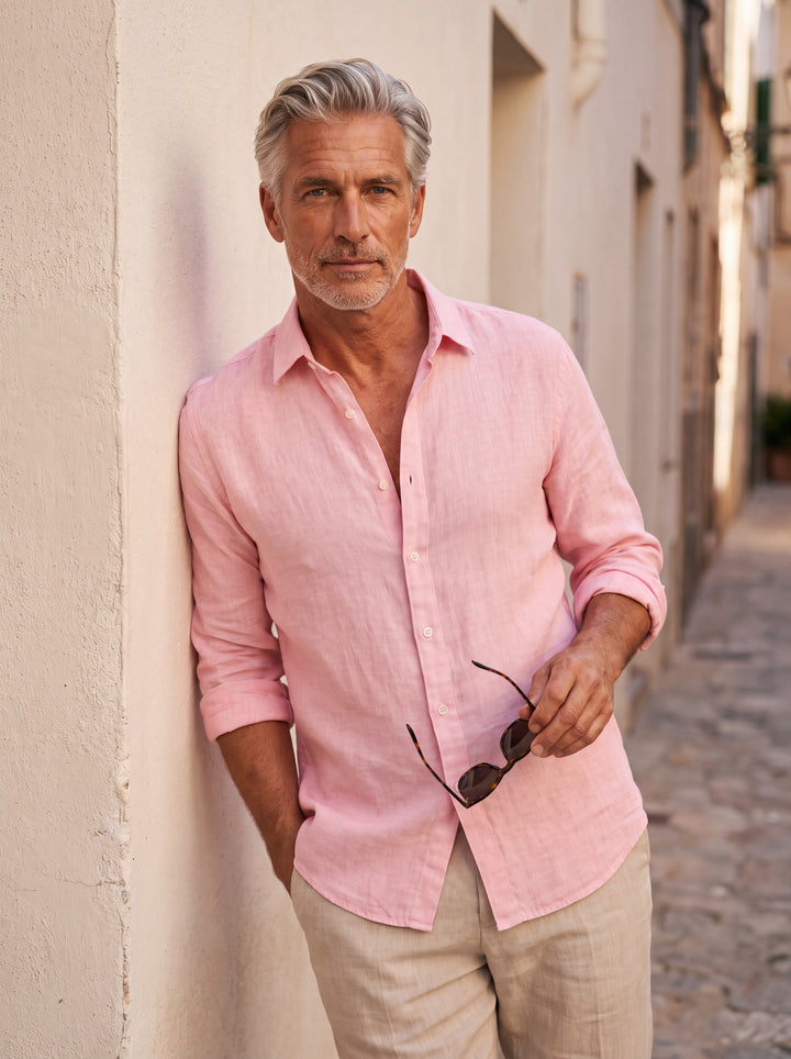 Coleman Men beach shirt in pink, worn by a model on a Mediterranean terrace - Gentlemens Manor lifestyle
