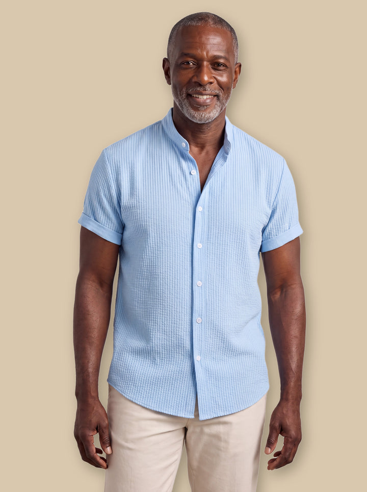 Corbin casual shirt in Blue, worn by a model on a warm sand studio background - Gentlemens Manor