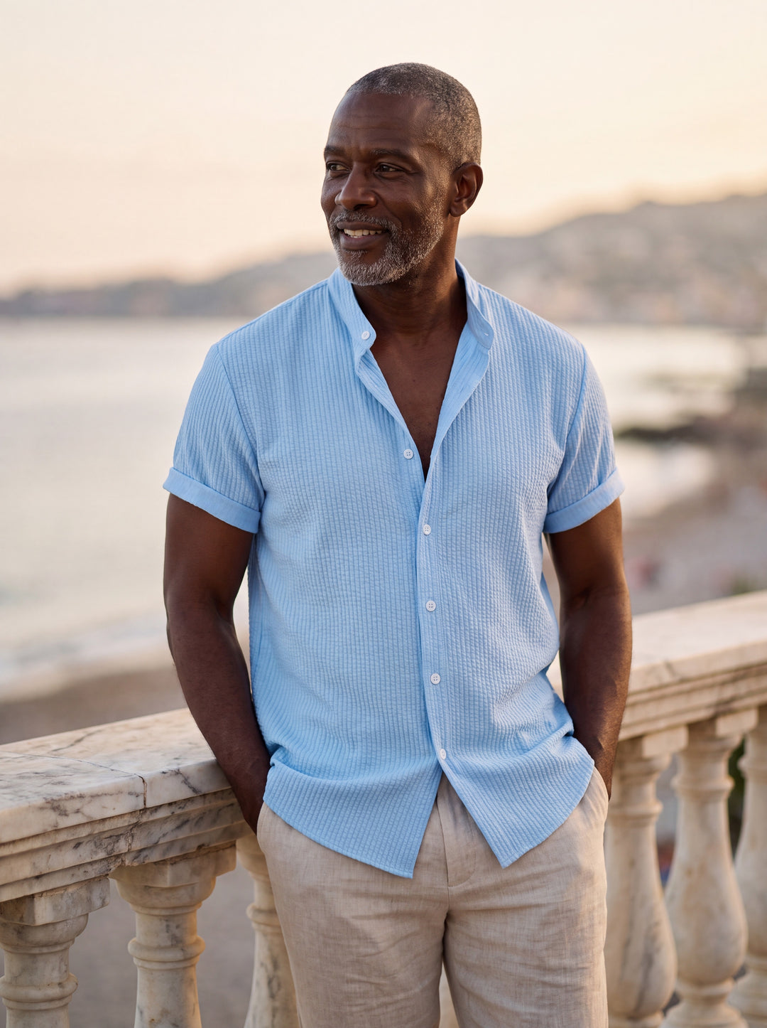 Corbin Men short sleeve shirt in blue, worn by a model on a Mediterranean terrace - Gentlemens Manor lifestyle