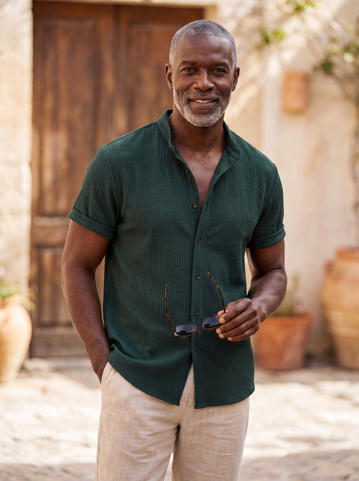 Corbin Men short sleeve shirt in green, worn by a model on a Mediterranean terrace - Gentlemens Manor lifestyle