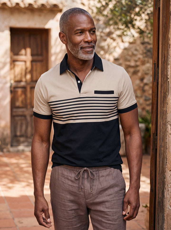 Crawford Men polo shirt in sand, worn by a model on a Mediterranean terrace - Gentlemens Manor lifestyle