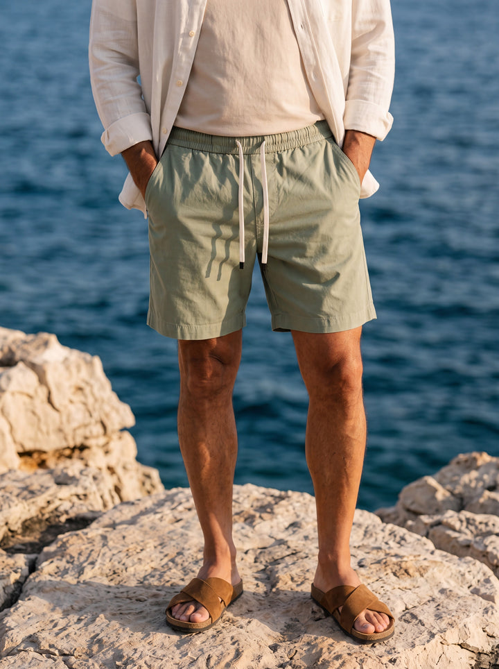 Crawford Men summer shorts in green, worn by a model in a Mediterranean setting - Gentlemens Manor lifestyle