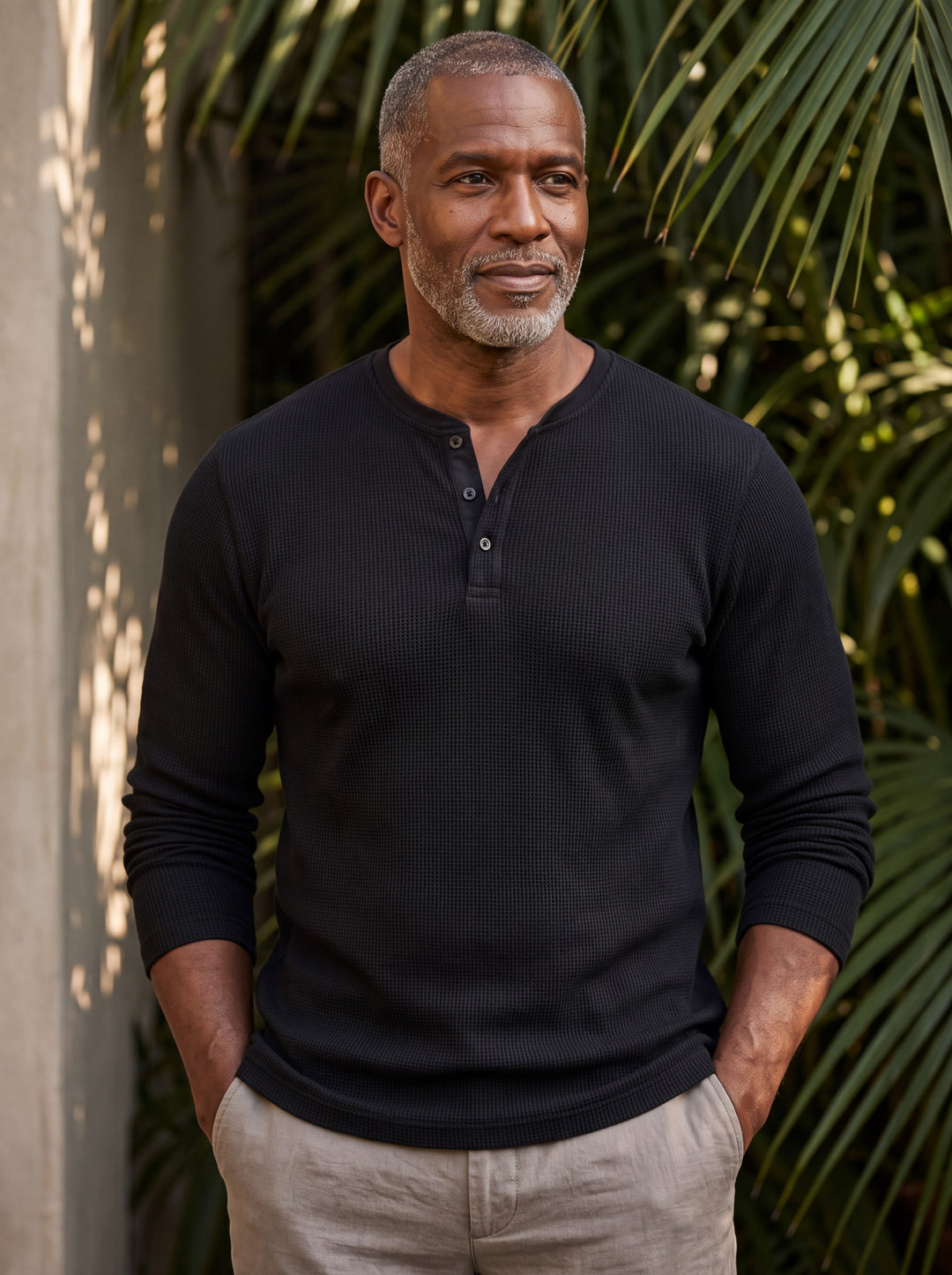 Cyrus Men henley shirt in black, worn by a model on a Mediterranean terrace - Gentlemens Manor lifestyle